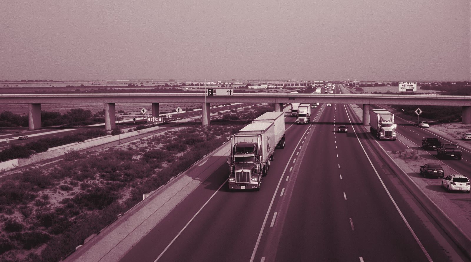Semi trucks on a wide interstate through South Texas brush country