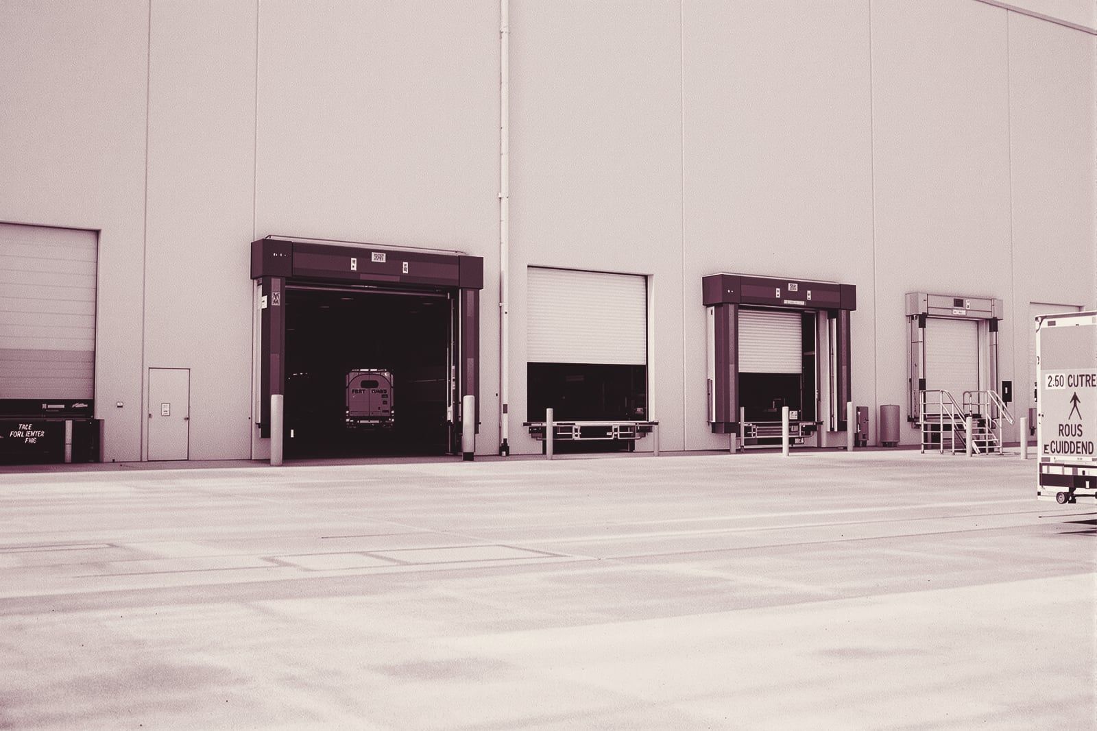 A warehouse loading dock with roll-up doors in an industrial park